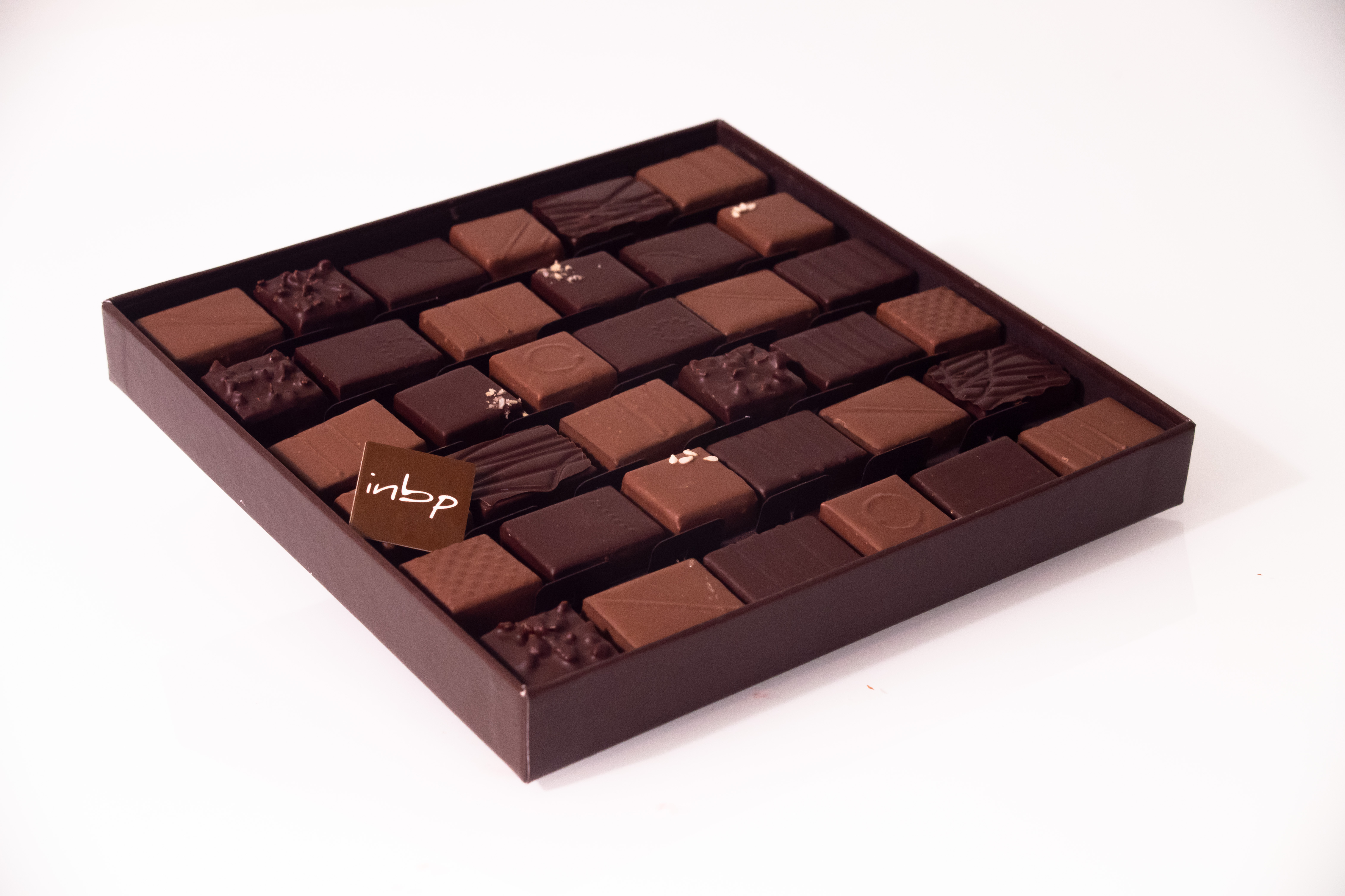 Photo au format paysage d'une boite contenant des chocolats carré créés par Jean-Pierre Godier de l'INBP de Rouen